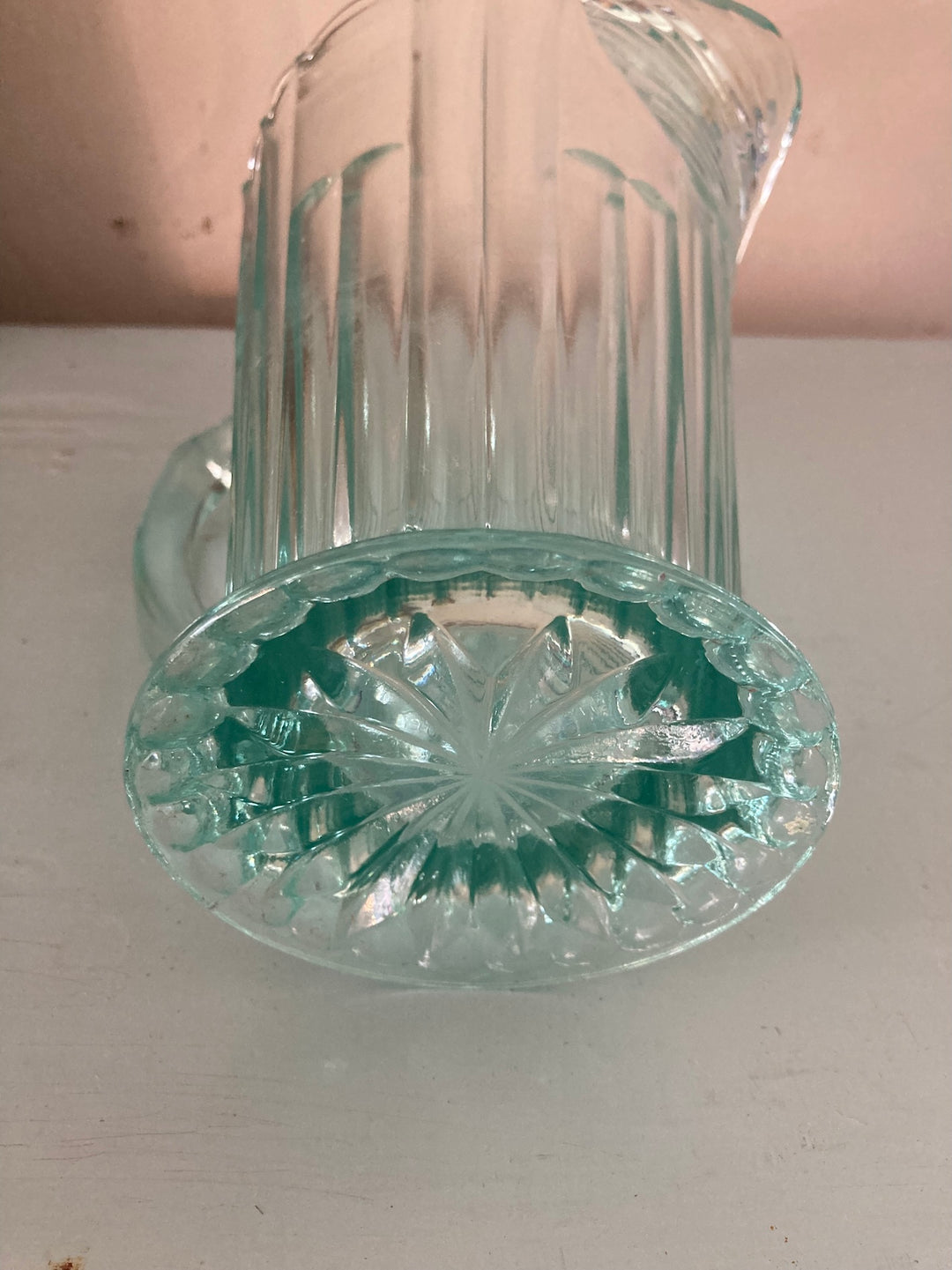 Base view of a Vintage 1930s Green Pressed Glass Jug, showcasing fluted design and stunning starburst pattern, from Source for the Goose, Devon.