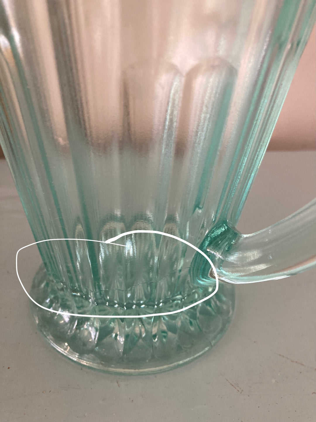 Close-up of a vintage 1930s green pressed glass jug highlighting its fluted design and beautiful green color.