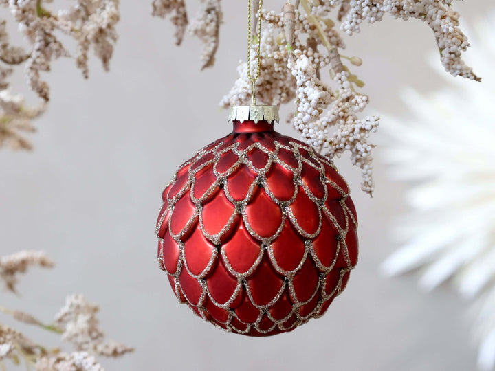 pretty red bauble with gold glitter edging overlapping scales 