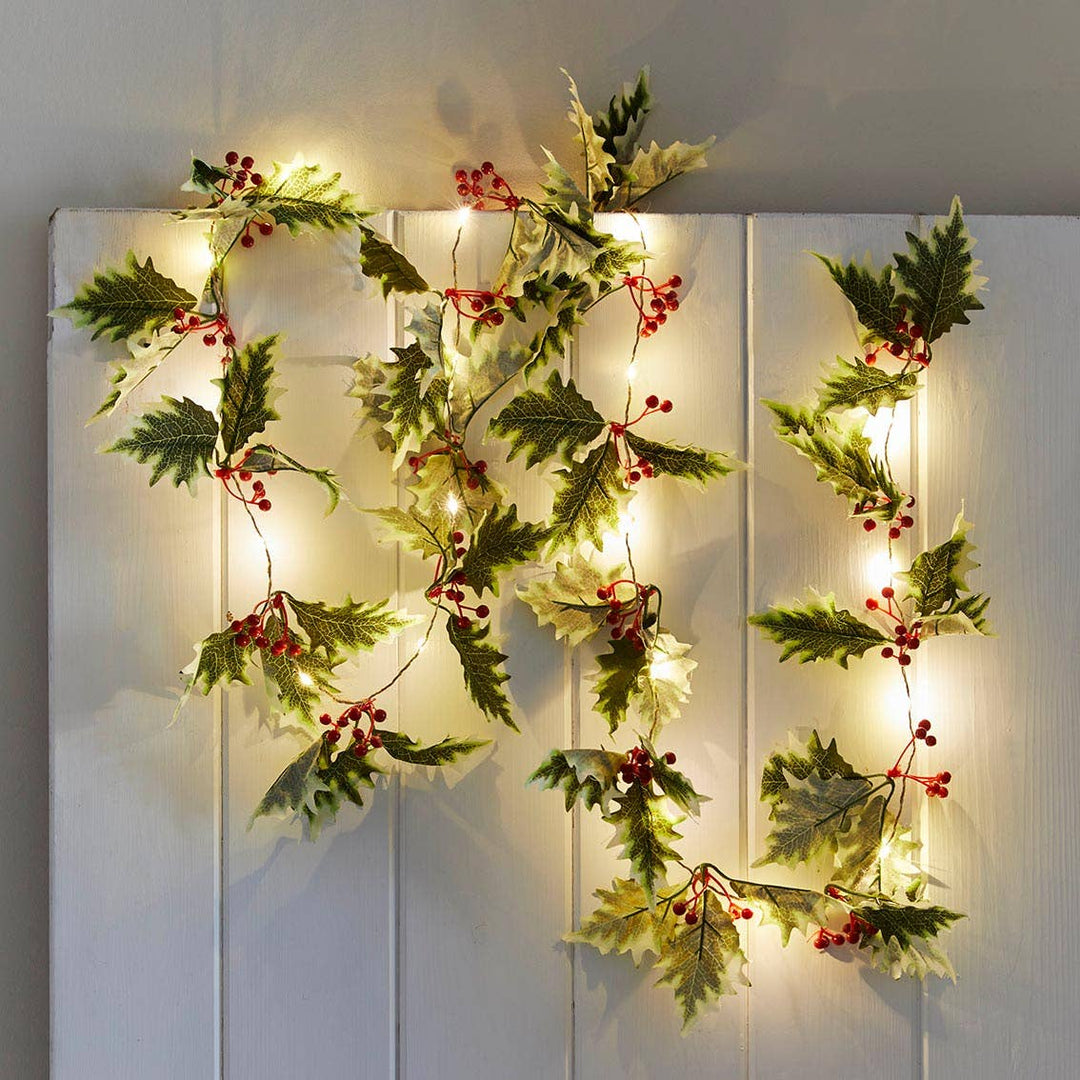 Holly Christmas LED string lights with fabric leaves and red berries, creating a festive ambiance. Available at Source for the Goose Devon.