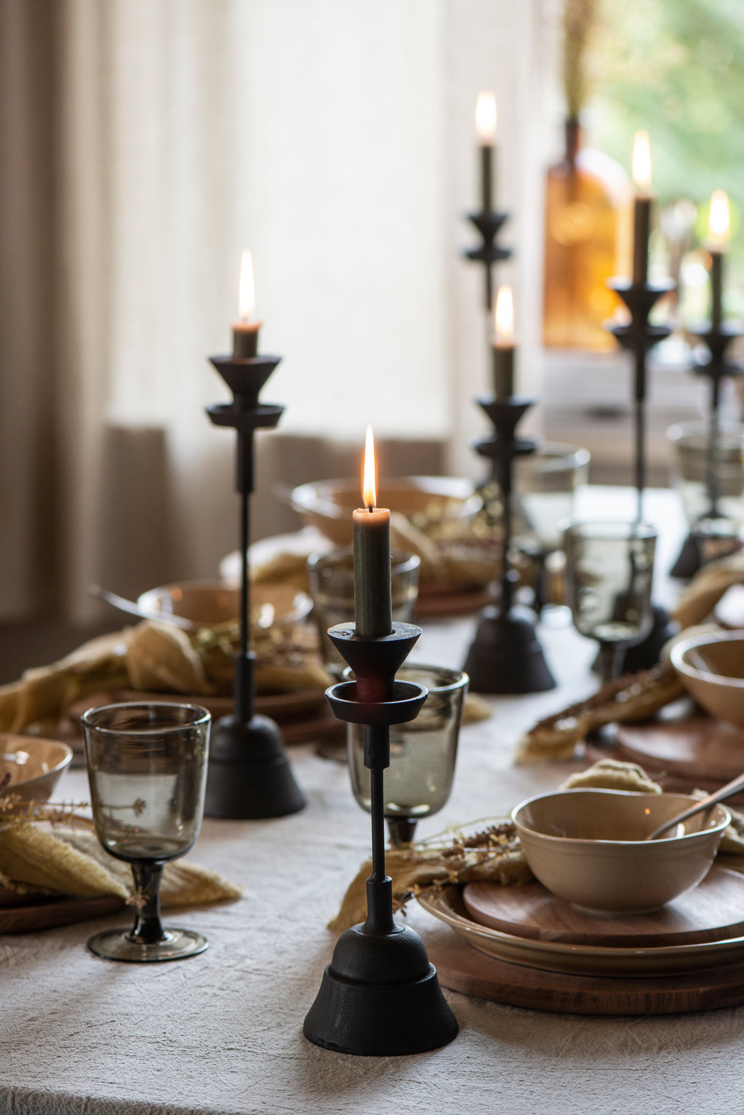 Chunky black iron candlesticks on a decorated dining table, creating an industrial vibe. Source for the Goose, Devon.