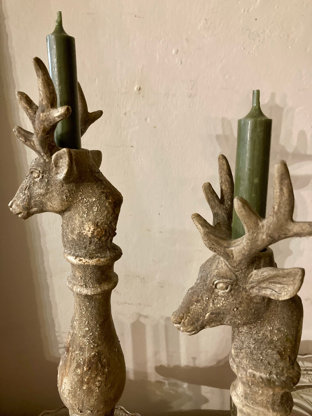 Vintage style deer candleholders with distressed stone finish and green candles, perfect for rustic decor from Source for the Goose, Devon.