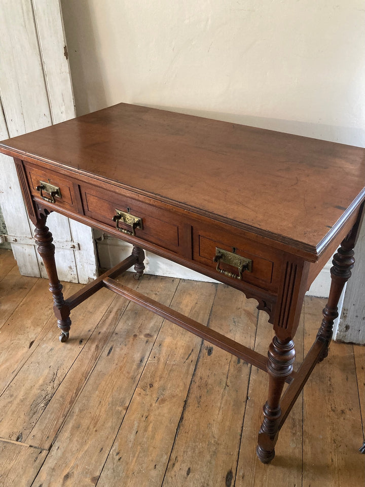 Antique Oak Console Table by JAS Shoolbred, featuring three brass-handled drawers and decorative carvings in Devon.