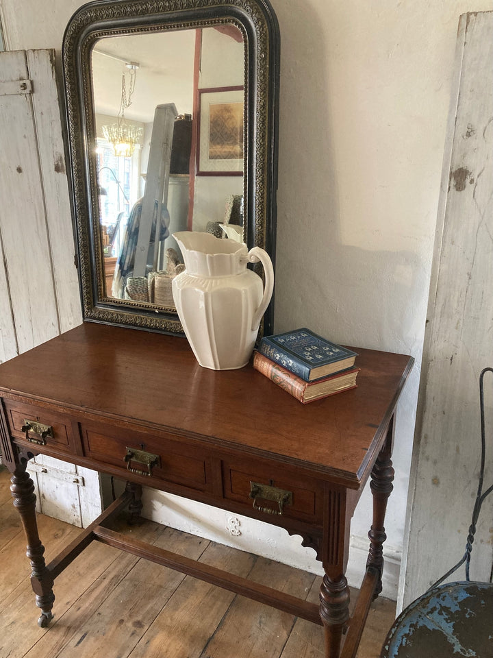 Antique Oak Console Table by JAS Shoolbred with mirror, pitcher, and books, showcasing classic Victorian charm. Source for the Goose, Devon.