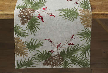 Embroidered Pine Cone Table Runner for Christmas by Source for the Goose Devon, featuring pine cones and greenery on a white fabric.