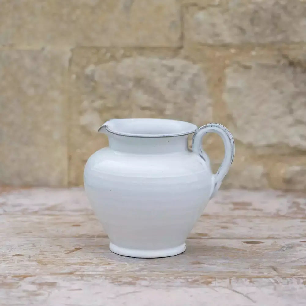 Handmade short glazed white ceramic jug with vintage style, ideal for rustic home decor and serving drinks, featuring a sturdy handle and spout.