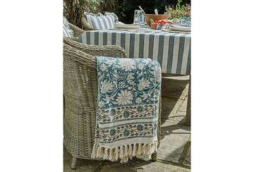 a pretty blue and cream cotton throw with tassels created by hand with wooden blocks