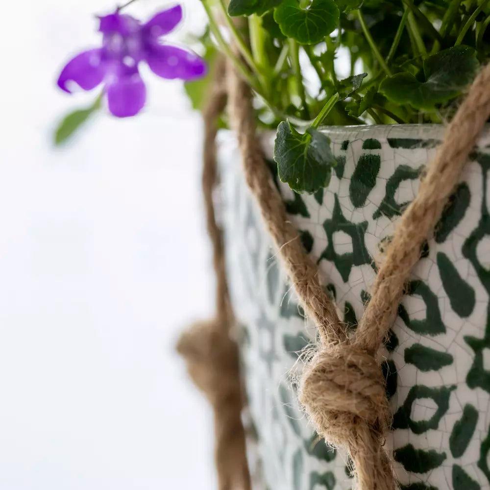 Jute plant hanger showcasing a green and white pot with purple flowers, perfect for herb and sun-loving plants from Source for the Goose