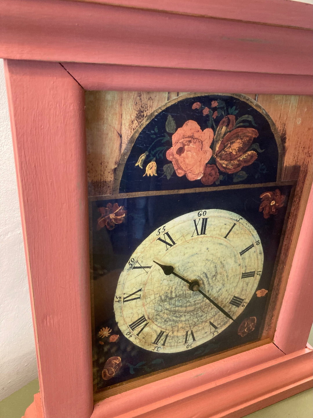 Country style painted wall clock with floral design and coral pink frame, perfect for adding vintage charm to your home.