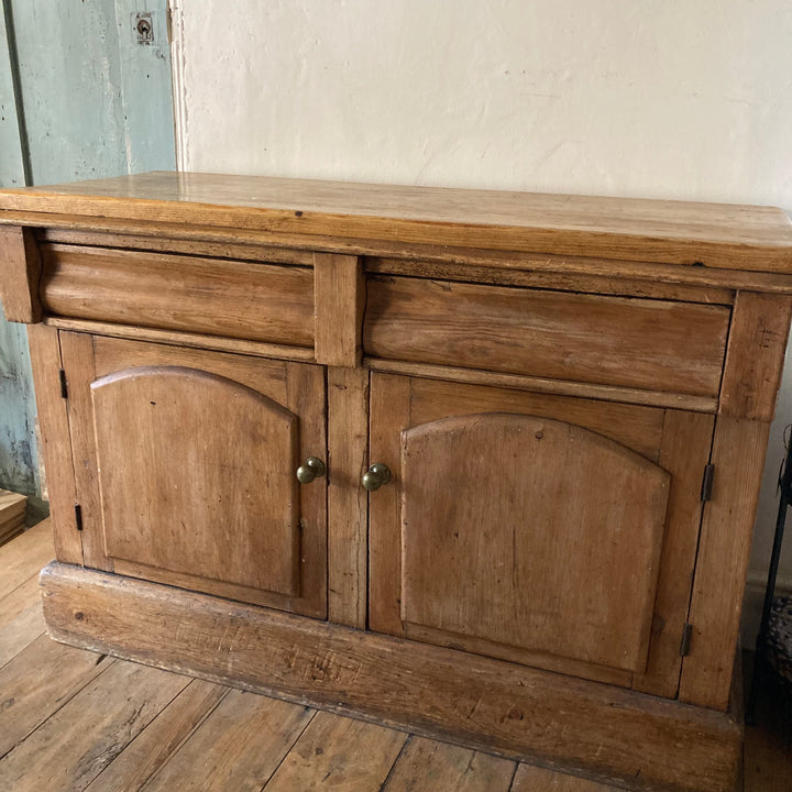 Rustic antique pine sideboard with two doors and drawers for storage, perfect for enhancing country-style decor.