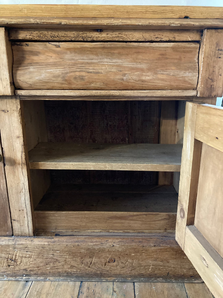 Interior view of a rustic antique pine sideboard showcasing a drawer and open cupboard space, sourced from Source for the Goose, Devon.