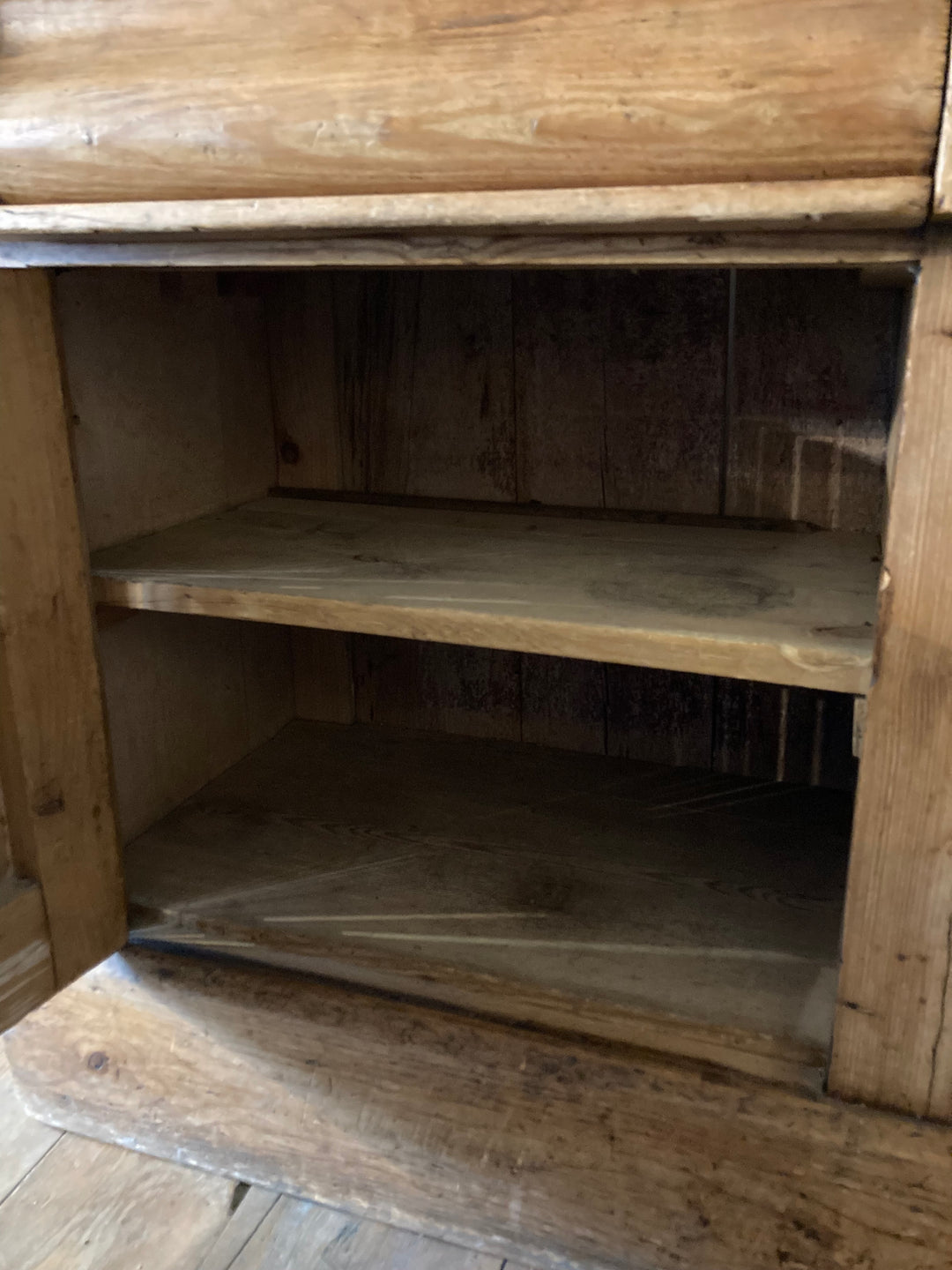 Rustic antique pine sideboard interior showing two spacious shelves for storage. Source for the Goose, Devon.