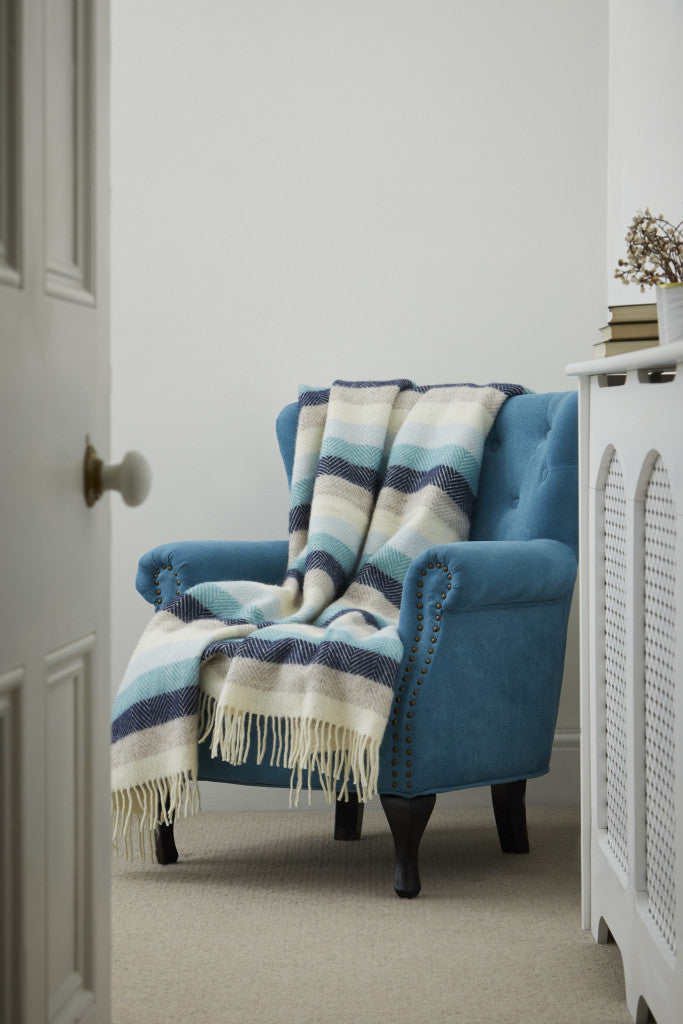 Tweedmill Seashore Blue Stripe Pure Wool Throw on blue armchair with cream fringe, available at Source for the Goose, Devon.