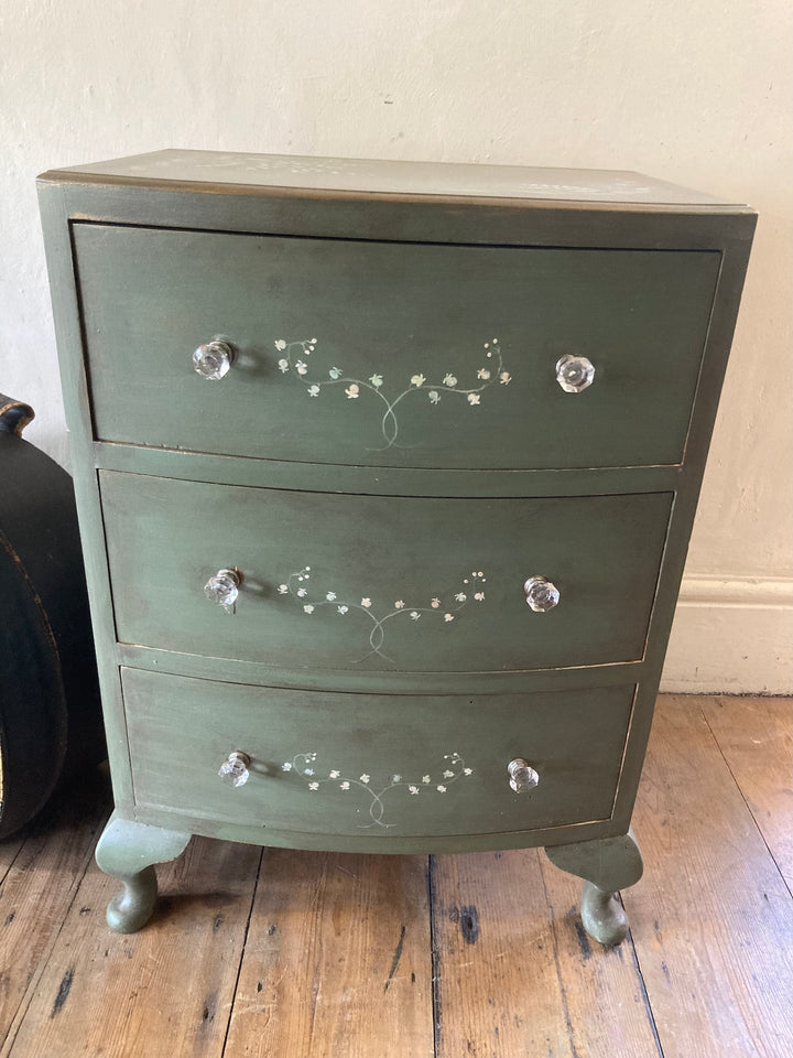 Small chest of drawers hand-painted with flowers in serene green, featuring three storage drawers and French style legs.