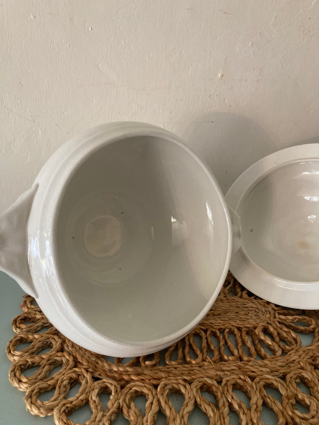 Inside view of a Large Antique White Tureen on a woven placemat, showcasing its elegant ceramic finish.