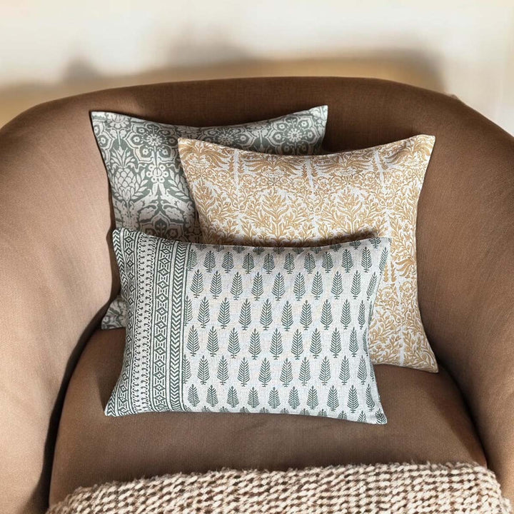 Sage green, yellow, and patterned cushions arranged on a cozy chair, enhancing a stylish home decor. Source for the Goose, Devon.