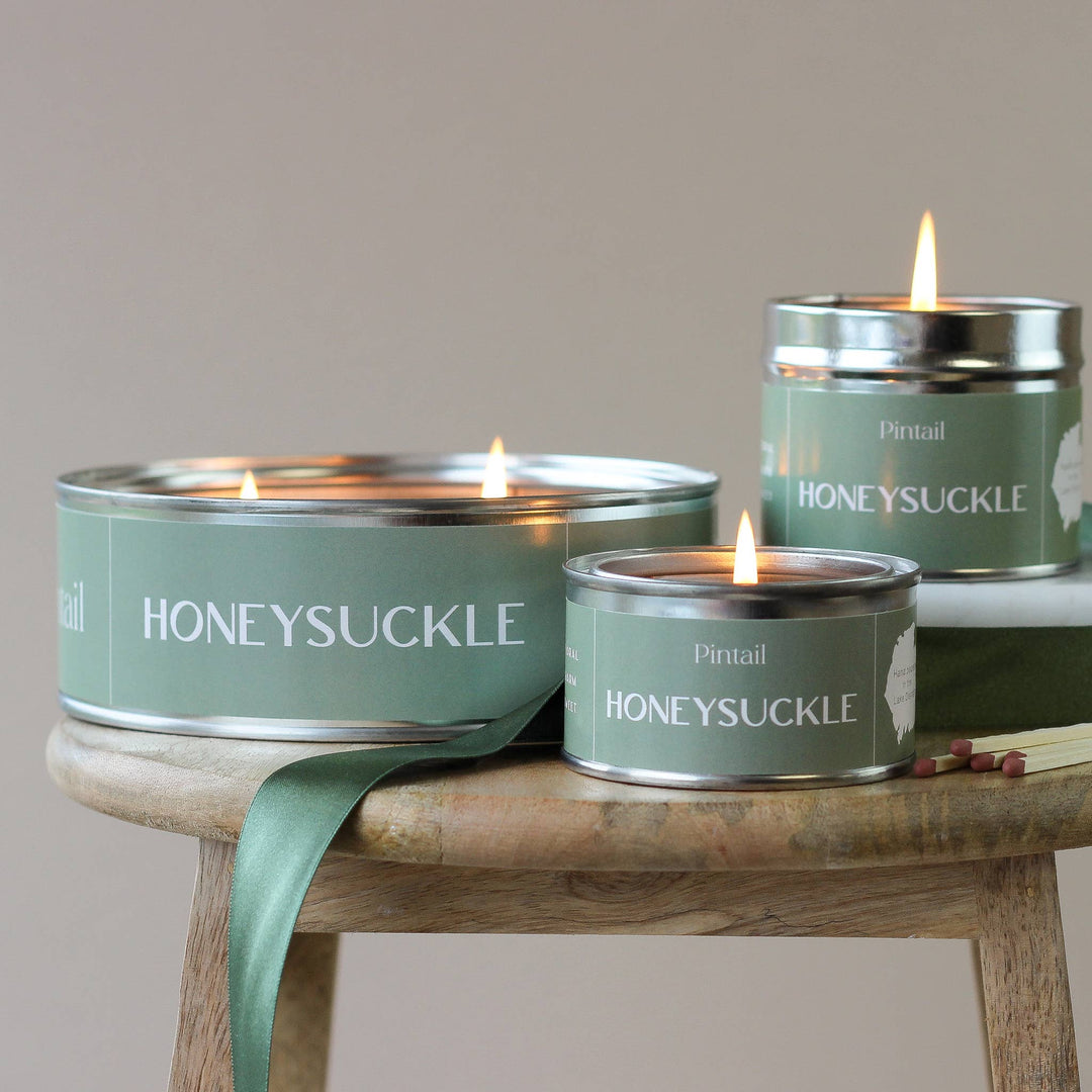 Pintail Honeysuckle candles on a wooden table, showcasing the soothing fragrance of an English garden.