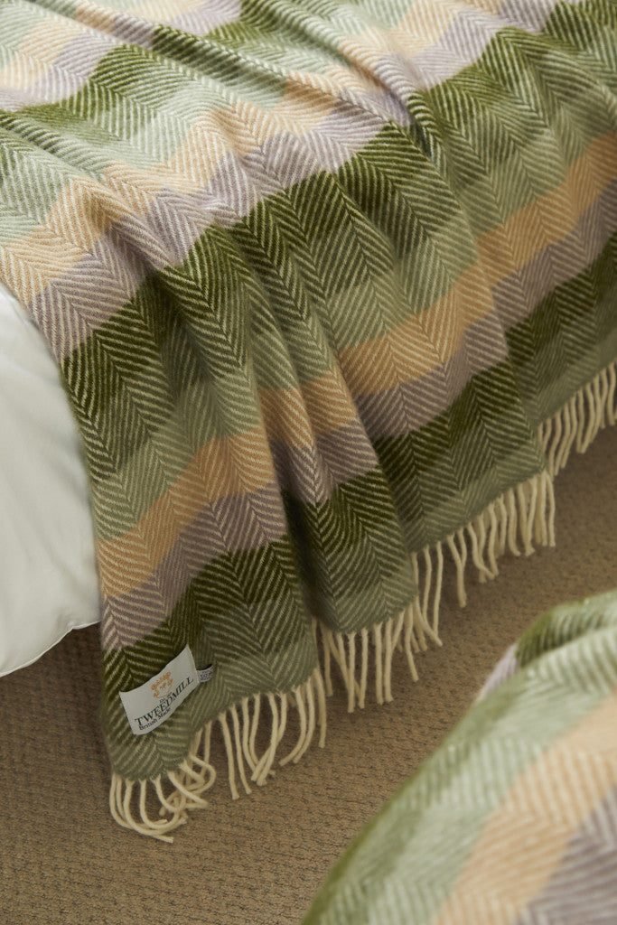 Tweedmill Botanical Green Stripe Pure Wool Throw with cream tassels on bed from Source for the Goose, Devon.