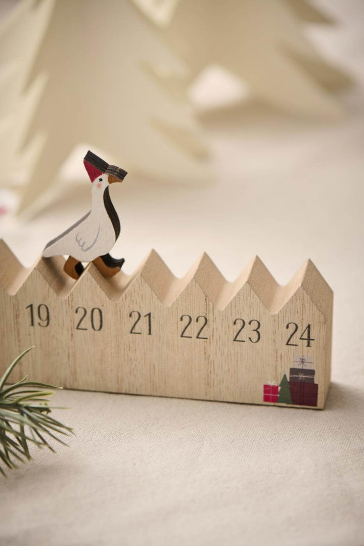 wooden goose walking on top of wooden advent calendar