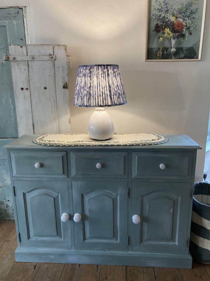 Slim Duck Egg Blue Sideboard with porcelain handles, styled with a lamp and decor, from Source for the Goose Devon.