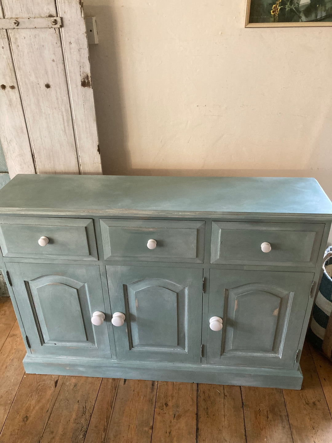 Slim Duck Egg Blue Sideboard with three cupboards and drawers, featuring white porcelain handles, from Source for the Goose, Devon.