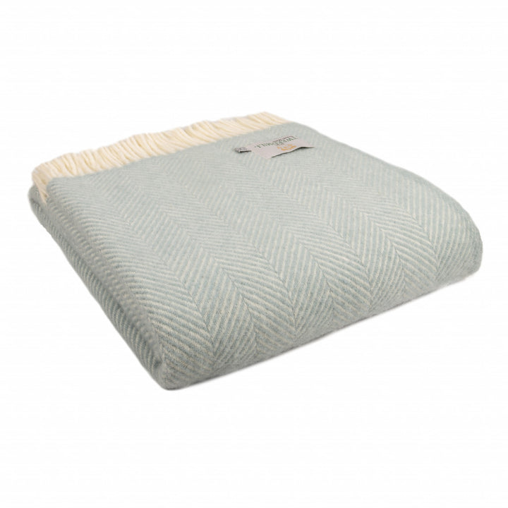 Tweedmill Fishbone Duck Egg Blue Blanket with cream tassels from Source for the Goose, Devon. Folded showcasing its cozy texture.