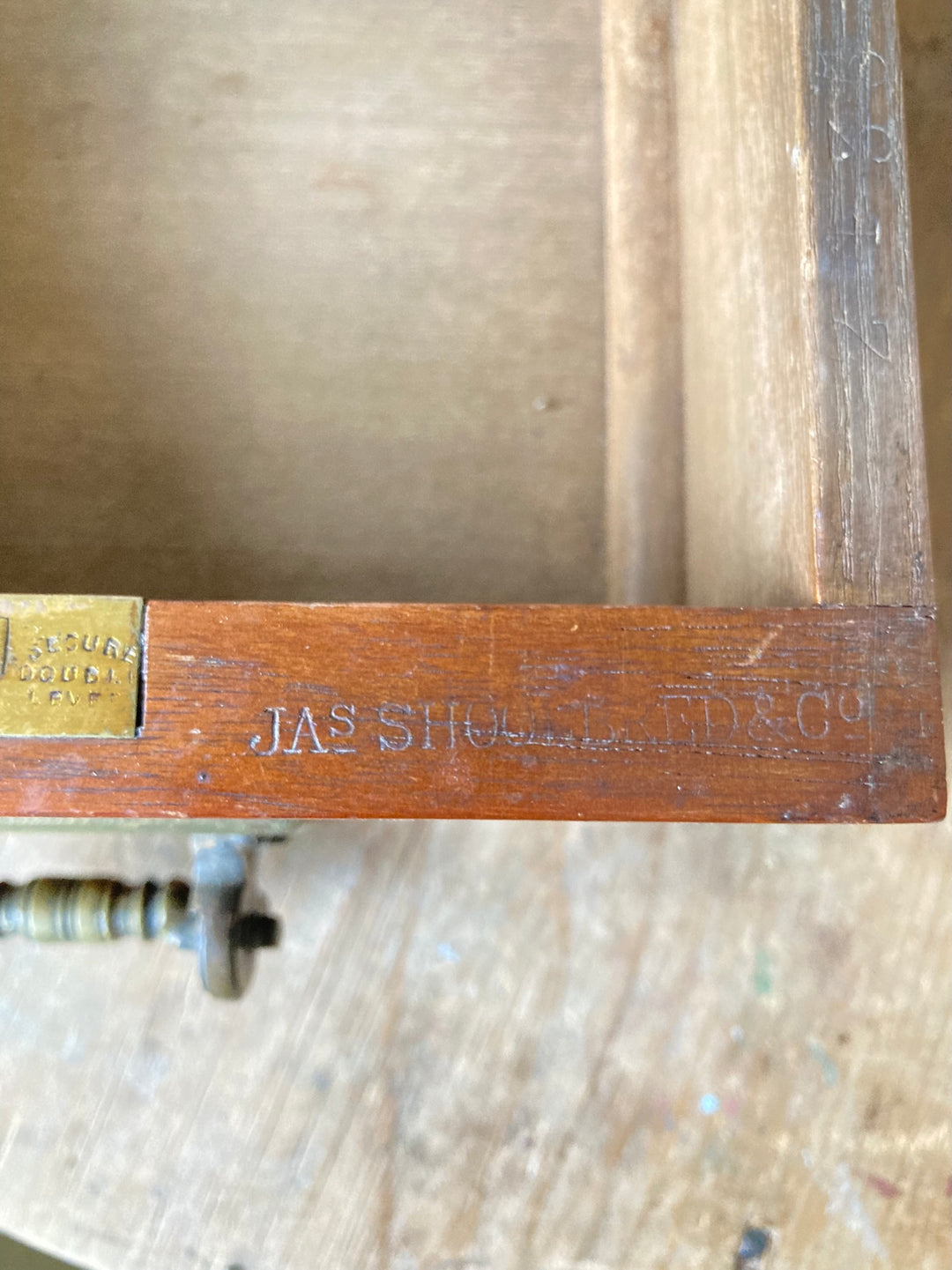 Close-up of the makers mark on an Antique Oak Console Table by JAS Shoolbred & Co, showcasing craftsmanship.