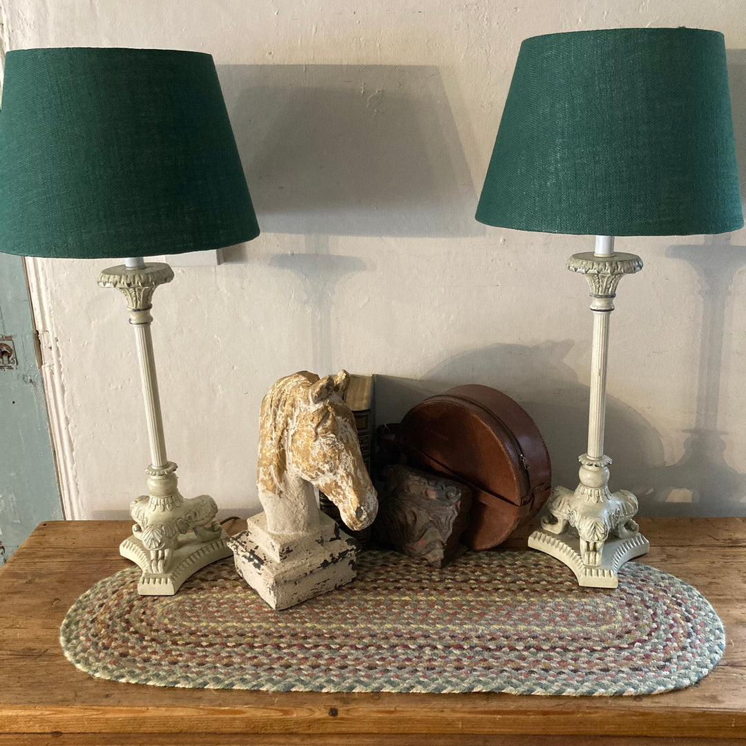 Pair of cream metal base lamps with green shades, styled on a table with decorative objects, by Source for the Goose, Devon.