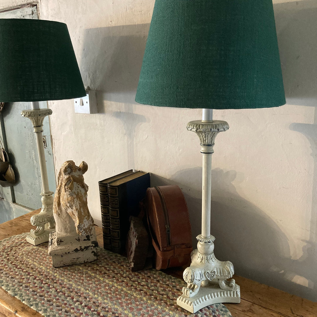 Pair of cream metal base lamps with green shades on a wooden table, adding elegance to the interior decor. Source for the Goose Devon.