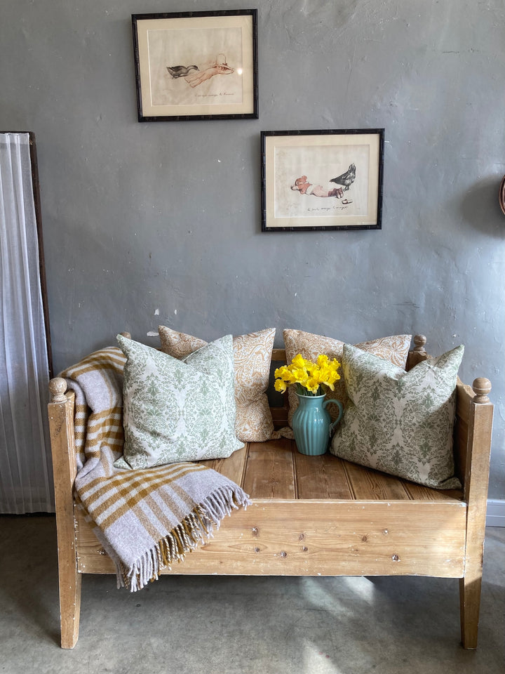 Vintage Pine Bench Seat by Source for the Goose in Devon, adorned with cushions and flowers, showcasing a rustic aesthetic.