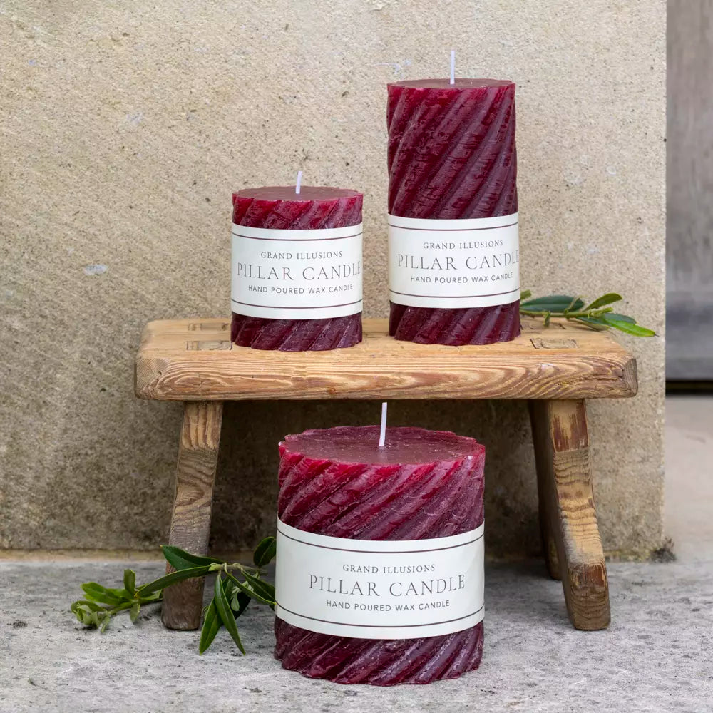 Twisted Plum Red Pillar Candles on wooden stool, hand poured wax, from Source for the Goose, Devon.