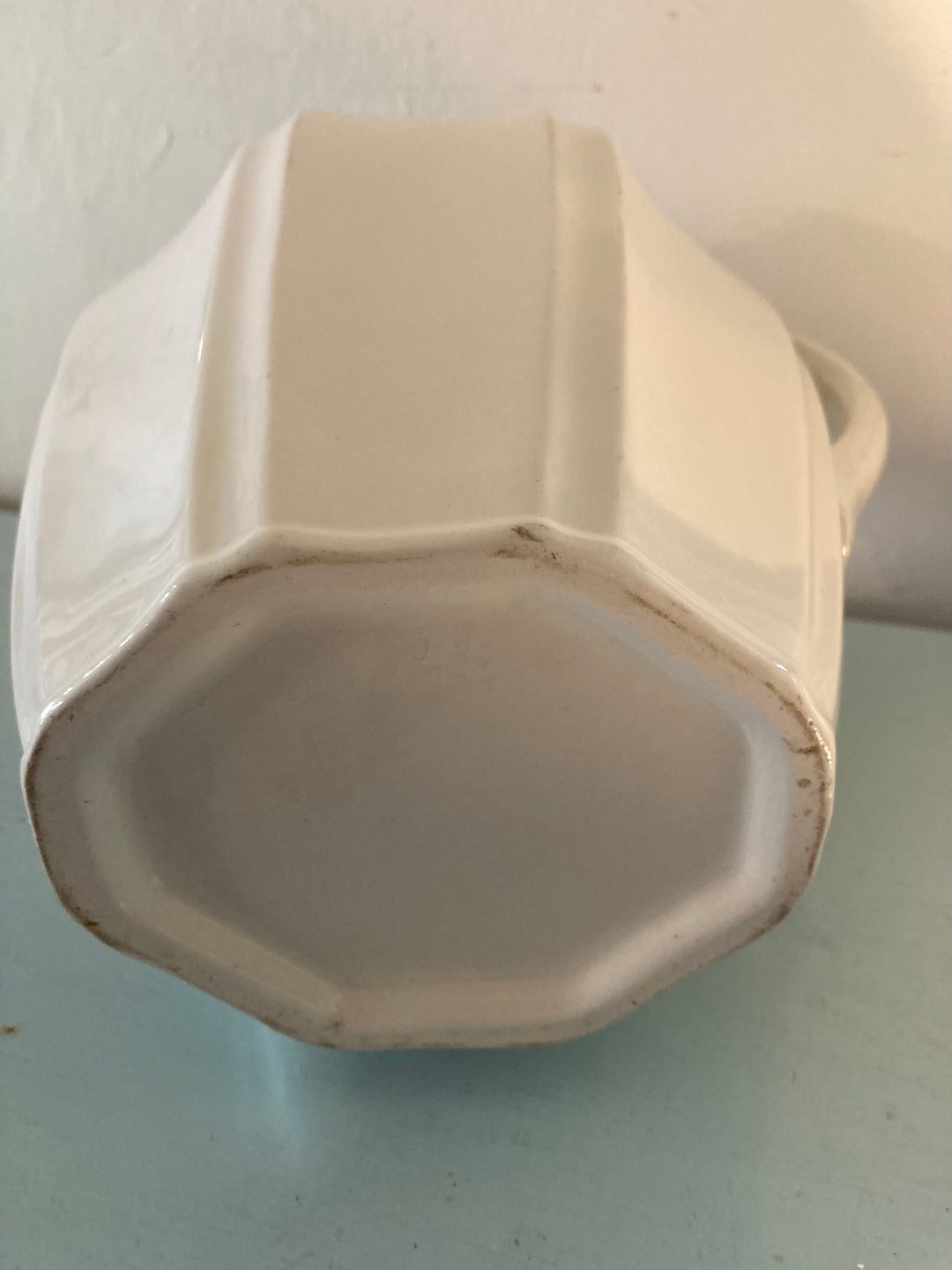 Large vintage white jug with fluted design viewed from the bottom, showcasing its elegant, creamy tone. Source for the Goose, Devon.